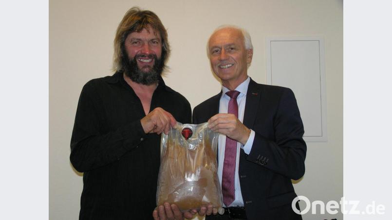 Aus der Hand von Ortsgemeinschaftsvorsitzenden Hans Scherm (links) durfte Neusorgs Bürgermeister Peter König für seinen Einsatz zur Verwirklichung des Gemeinschaftshauses einen Fünfliter-Beutel Apfelsaft in Empfang nehmen. Bild: öt