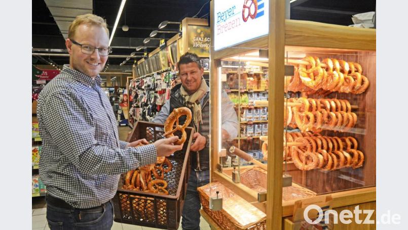 Mehrmals täglich wird der SB-Automat im E-Center Grünbauer mit frischen Brezen bestückt. Philipp Beyer (links), Inhaber der gleichnamigen Bäckerei tüftelte das Konzept aus. Klaus Grünbauer vom E-Center findet die Idee gut. Bild: Gabi Schönberger