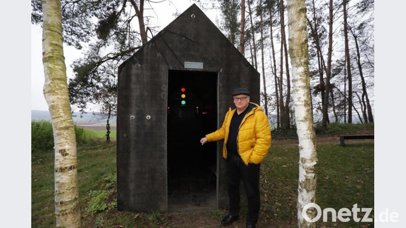 Wilhelm Koch öffnet die nicht vorhandene Tür zur Asphaltkapelle in Etsdorf (Amberg-Sulzbach). Der Griff in die Luft ist für den Künstler kein Problem, schließlich ist er auch der Leiter des Amberger Luftmuseums. Bild: Wolfgang Steinbacher
