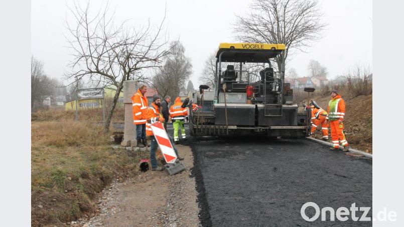 Bürgermeister Johann Maurer (Dritter von links) verfolgt mit Tobias Dunkl (recht) sowie Johann Völkl und Thomas Schaller (von links) die Asphaltierungsarbeiten. Bild: pi
