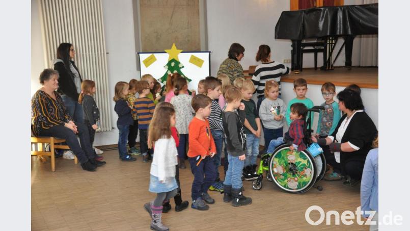 Kinder bekleben den Christbaum aus Pappe mit Sternwünschen Bild: ak