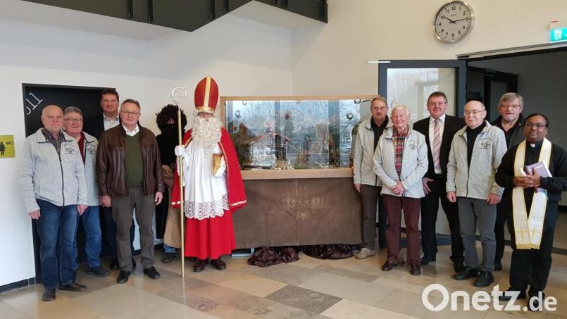 Nach der Übergabe der selbstgebauten Krippe mit (von links): Heinz Krause, Wolfgang Moll, Konrektor Peter Großmann, Heinrich Ruppert (3. Bürgermeister), Knecht Ruprecht (Gerhard Schneider), Nikolaus Thorsten Grädler (2. Bürgermeister), Konrad Gebert, Hans Grimm, Bürgermeister Hans-Martin Schertl, Johann Maul, Wolfgang Albersdörfer und Pfarrvikar Hrudaya Kumar Madanu. Bild: khg