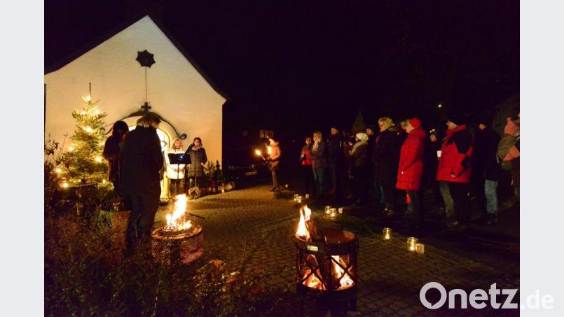 Vor der Dorfkapelle singt "ChorAhnung", die Besucher der Dorfweihnacht suchen die Nähe der offenen Feuer oder wärmen sich an der heißen Glühweintasse samt Inhalt. Bild: bey