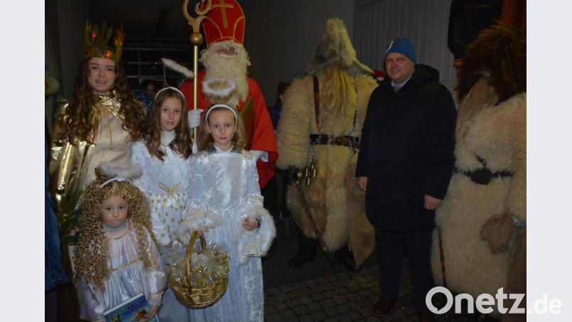 Christkind Lara Zeitler (links) erschien bei der zweiten „Adventsschaufenster“-Aktion mit drei Engeln, dazu gesellten sich der Nikolaus und zwei Knechte. Gewerbefördervereins-Vorsitzender und Zweiter Bürgermeister Stefan Grillmeier (Zweiter von rechts) führte durch das Programm. Bild: jr