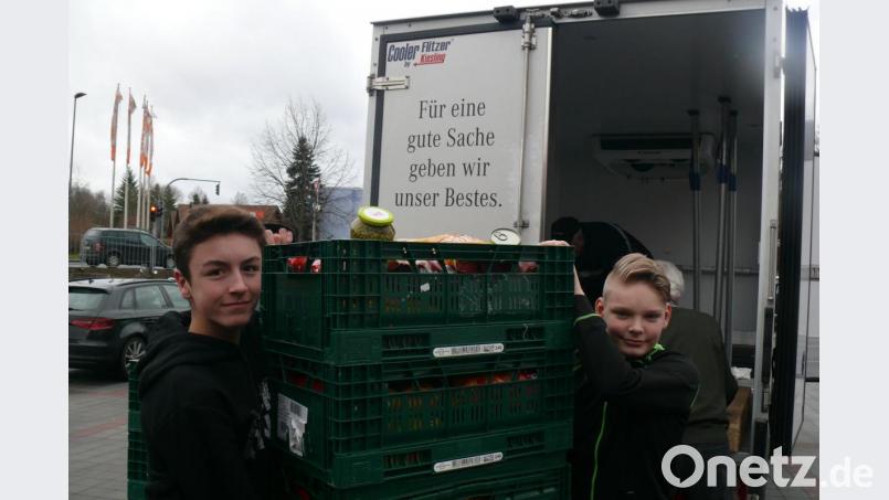 Die Realschüler Michael Bär (links) und Florian Sollner wuchten die mit Nahrungsmittel prall gefüllten Kisten in den Lkw der Amberger Tafel. Bild: lhc