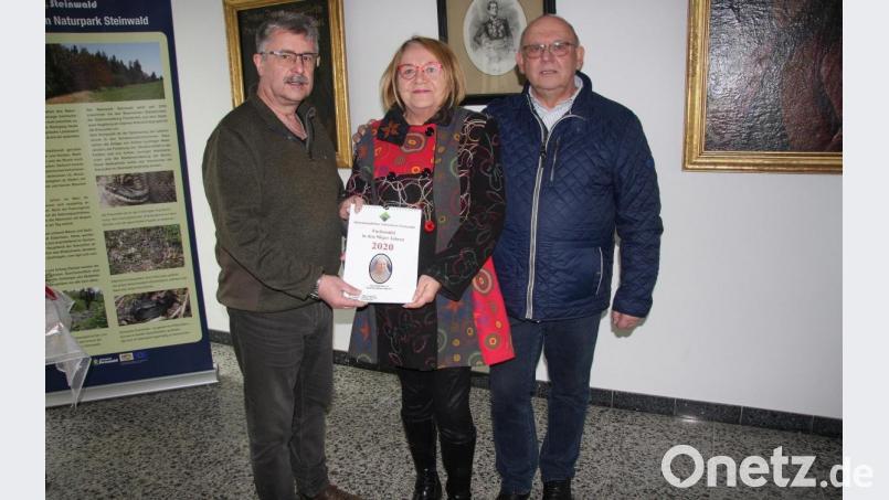 Das erste Exemplar des neuen Heimatkalenders bekam - aus den Händen von Bürgermeister Wolfgang Braun (links) - die Witwe des langjährigen Kalender-Machers, Angela Sperrer. Das aktuelle Exemplar wurde von Erich Schraml (rechts) vorgestellt. Bild: wro