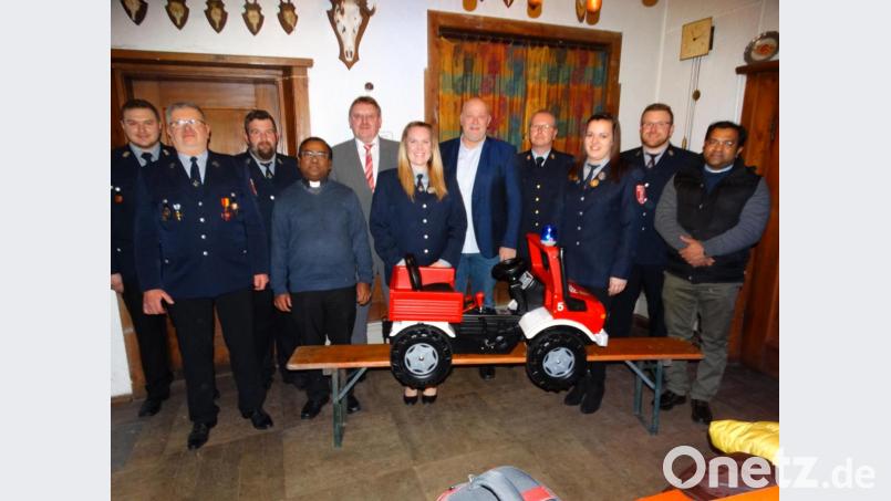An die Kinderfeuerwehr überreichte Peter Lehner ein ganz spezielles „Einsatzfahrzeug“ (von links): Zweiter Kommandant Markus Heuberger, Vorsitzender Siegfried Herlitze, dessen Stellvertreter Josef Ströhl, Pfarrvikar Hruday Madanu, Bürgermeister Hans-Martin Schertl, Bettina Geier, Peter Lehner, Kreisbrandinspektor Christof Strobl, Lena Lautner, Kommandant Stefan Geier und Stadtpfarrer Robin Xavier. Bild: ct