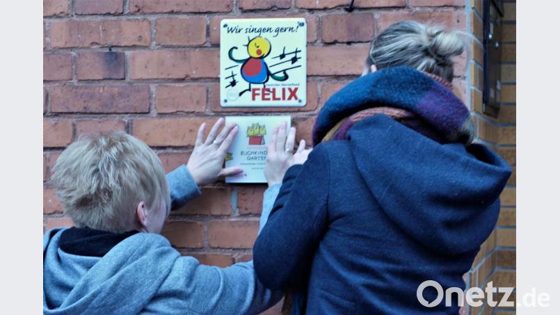Das Gütesiegel Buchkindergarten wird angebracht. Bild: wbe