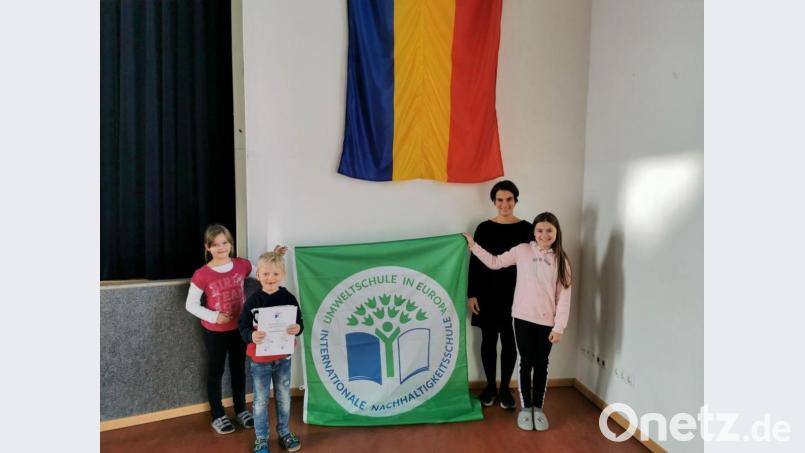 Stolz präsentieren die Klassenvertreter Sophie Rauch (von links), Lorenz Kleber und Mia-Sophie Gawel gemeinsam mit stellvertretender Schulleiterin Alexandra Reber das grüne Banner und die Urkunde. Bild: gz