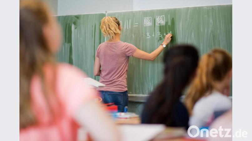 Eine junge Lehrerin schreibt an eine Schultafel. Symbolbild: Julian Stratenschulte/dpa