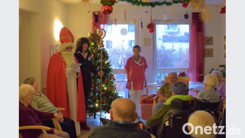 In jedem der drei Bereiche des BRK-Seniorenheims spricht der Nikolaus mit den Bewohnern, trägt ihnen ein Gericht vor und verteilt süße Kleinigkeiten. Ines Zeitzer von der Verwaltung darf den Bischofstab halten. Bild: gpa