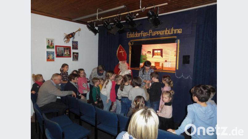 Nach der Vorstellung verteilt Nikolaus, der noch kurz vorher in der Geschichte des Puppentheaters in eine Tanne verzaubert worden war, Geschenke an die Kinder. Bild: pap