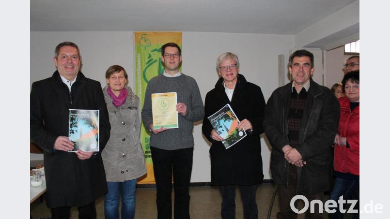 Nach dem Festgottesdienst präsentieren (von links) Bürgermeister Joachim Neuß, Barbara Persau-Kroher, Pfarrer Moritz von Niedner und Ulrich Deinzer eine Ausgabe der Umwelterklärung. Bild: cs