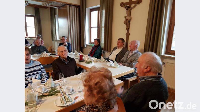 Pater Adrian Kugler (hinten, Zweiter von rechts) lauscht zusammen mit Annemarie Prüschenk-Wiesnet (links daneben) und den anderen Besuchern den Weihnachtsweisen. Bild: hzi