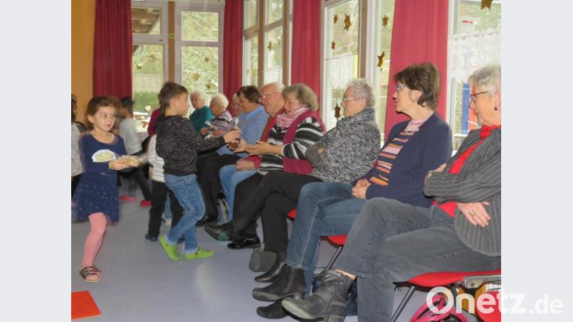 Mit einem Stollen beschenken die Kinder die Senioren. Bild: adj