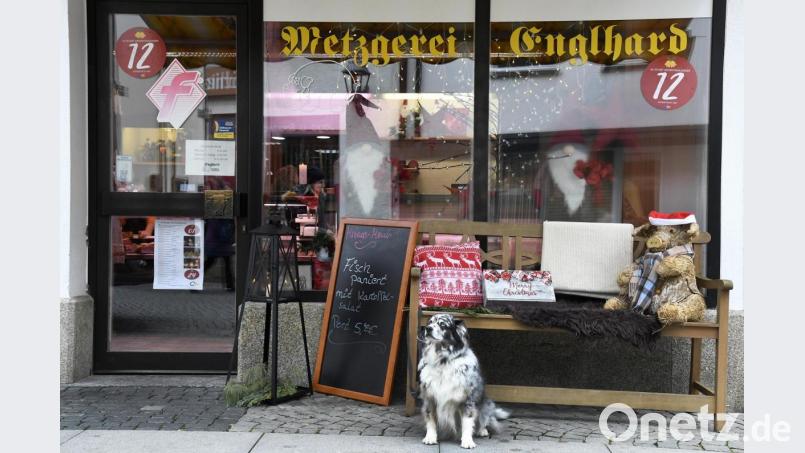 Eingerahmt von „Fisch paniert“ und wartendem Hund wartet auch das Deko-Strohschwein auf seiner Bank vor der Metzgerei Englhard auf seine Genehmigung und denkt sich wohl derweil: „Ich glaub, mein Schwein pfeift.“ Bild: Petra Hartl
