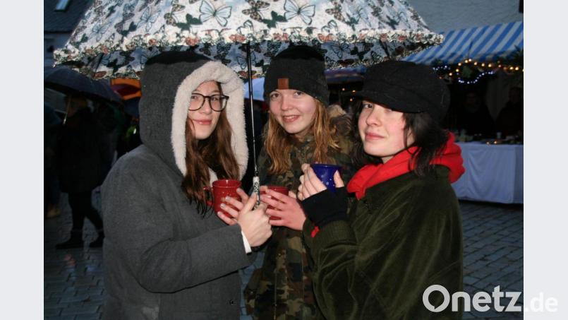 Unter einem Regenschirm haben auch schon mal drei Leute mit Glühweinbechern Platz, wenn es sein muss. Bild: fpoz