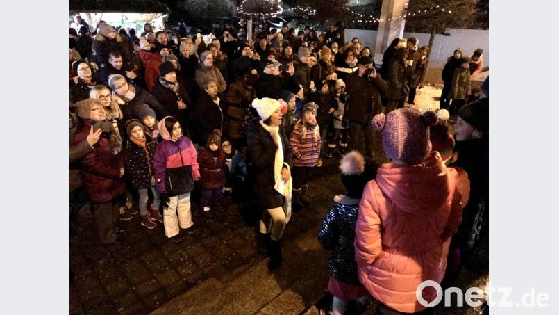 Der Kirchenvorplatz ist voll, als die Kinder der Kindertagesstätte und das Christkindl den kleinen Markt eröffnen. Bild: eig