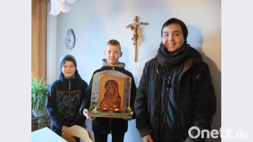 Die Messdiener Noah, Oliver und Tim (von links) mit dem hübsch geschmückten Marienbild bei einer Familie. Sie vollziehen den althergebrachten religiösen Brauch des Frauentragens zur Ehre Gottes. Bild: gm