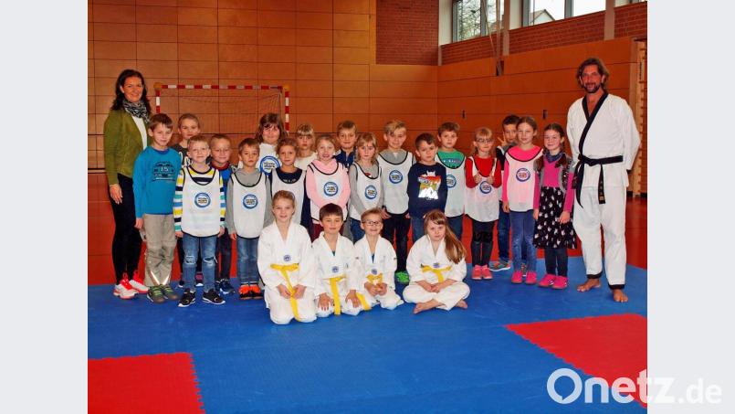 Rektorin Christine Kölbl (links) mit der Klasse 2a nach der Taekwondo-Schnupperstunde mit Trainer Manfred Dotzler-Brenner (rechts) und seinem Team Hanna, Andreas, Florian und Lilit (vorne von links). Bild: sön