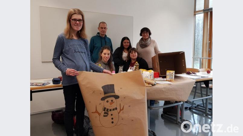 Schüler des BVB packen mit Volker Schmitt (Dritter von rechts) und Verena Mardanow (rechts) Pakete für die Hilfsaktion der Johanniter Weihnachtstrucker. Bild: exb