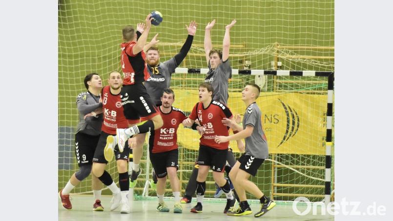 Die Amberger Sean Turner (Nr. 15) und Philipp Lulla (rechts daneben) machen sich beim Sprungwurf des Sulzbacher Rückraumspielers Marco Schmidt (links vorne) ganz lang. Bild: Hubert Ziegler