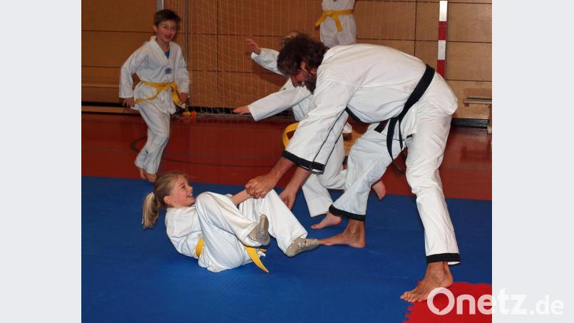 Taekwondo-Trainer Manfred Dotzler-Brenner bei einer Wurf-Demonstration mit Hanna, der man die Freude am Sport ansieht. Bild: sön