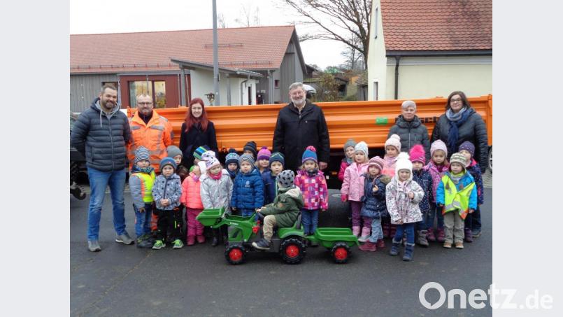 Bürgermeister Josef Schmidkonz (Mitte) freut sich über den neuen Tandemanhänger, die Kinder des Kinderhauses „Dorfpiraten“ freuen sich über den Spielzeugtraktor mit Anhänger. Bild: exb