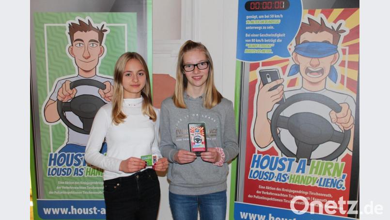 Katrin Schuller (links) und Marika Eckstein vor dem &quot;Houst a Hirn, lousd as Handy lieng&quot;-Motiv, das auch auf dem Flyer abgedruckt ist. Es verdeutlicht auf überspitzte Art den Blindflug, wenn beim Autofahren das Mobiltelefon in der Hand ist. Bild: sfo