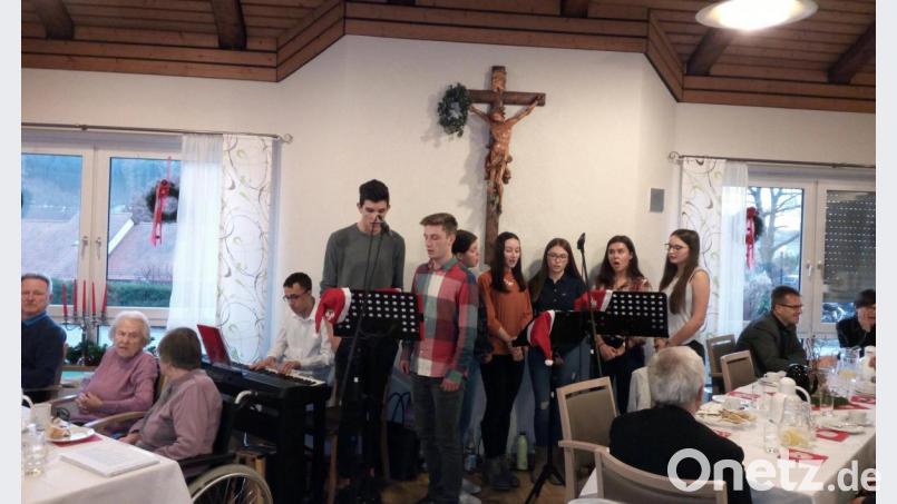 Schüler aus der Q12 des Gymnasiums gestalten mit Bewohnern und ehrenamtlichen Helfern eine Adventsfeier im Alten- und Pflegeheim St. Martin. Bild: bgm