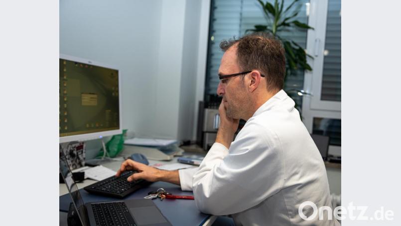 Als Oberarzt hat Jens Schlör auch administrative Tätikeiten zu erledigen. Gleichzeitig wird am Telefon seine medizinische Expertise benötigt. Bild: Christian Lingl