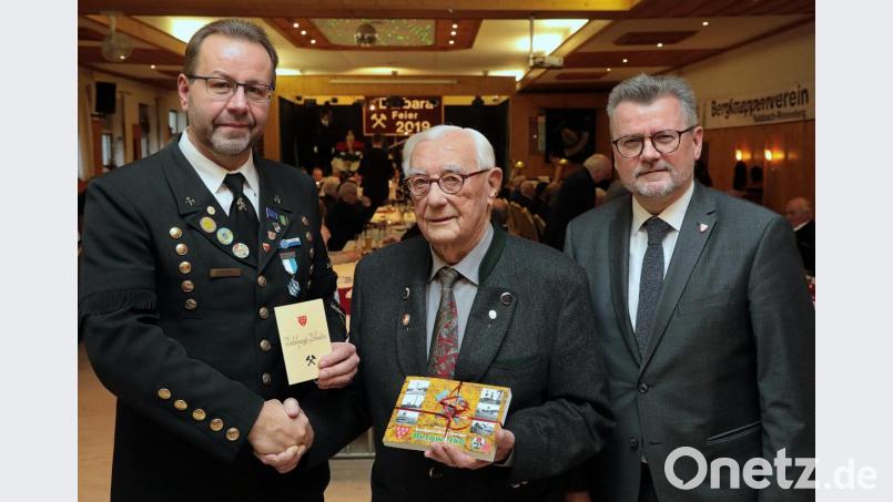 Bergknappen-Vorsitzender Armin Kraus (links) zeichnet Franz Luber mit der Ehrennadel in Gold für 70 Jahre Mitgliedschaft aus. Dazu gratuliert auch Bürgermeister Michael Göth. Bild: Wolfgang Steinbacher
