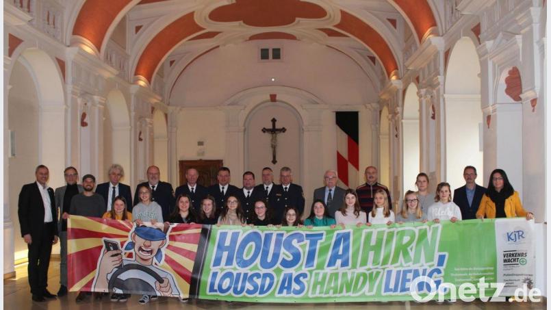 &quot;Houst a Hirn, lousd as Handy lieng&quot;, heißt es auf dem Banner. Unser Bild zeigt Kreisjugendring-Vorsitzenden Jürgen Preisinger (links), Landrat Wolfgang Lippert (Vierter von links), Polizeipräsident Norbert Zink (Fünfter von links), Bürgermeister Bernd Sommer (Zweiter von links), Philipp Reich vom Jugendmedienzentrum T1 (Dritter von links), Mädchenrealschulleitern Kerstin Reiter (rechts), Beamten der Polizeiinspektionen Tirschenreuth, Waldsassen und Kemnath, Vertreter der Verkehrswachten Tirschenreuth und Kemnath und Schülerinnen der Klasse 8b der Mädchenrealschule. Bild: sfo