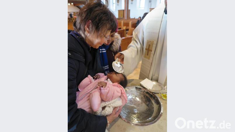 Die Paten trugen die Babys nach vorn, wo ihnen Pater Paul die Taufe spendete. Bild: ubb