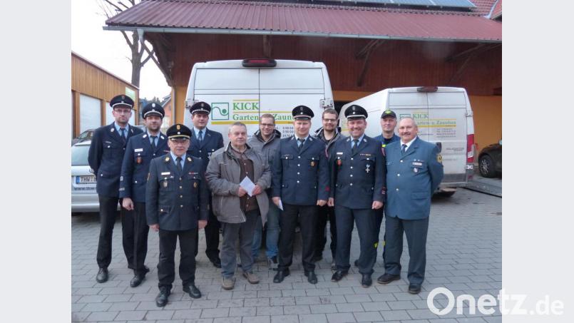 Johann Kick (Mitte) übergibt mit seinen Söhnen Georg (Vierter von rechts) und Johannes (Sechster von rechts) je 250 Euro an die drei Feuerwehren der Marktgemeinde Luhe-Wildenau und an das THW Weiden. Mit dem Geld sollen es sich die Einsatzkräfte nach den harten Einsätzen gut gehen lassen und feiern. Bild: hme