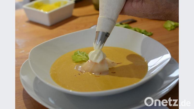 Das Sahnehäubchen: Die Jakobsmuschelsuppe wird mit Safranfäden und Staudensellerie-Blättern garniert. Bild: Gabi Schönberger