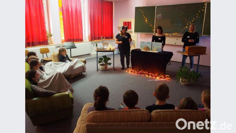 Die Kinder lauschen gespannt der Geschichte, die die Studierenden vorbereitet haben. Bild: exb