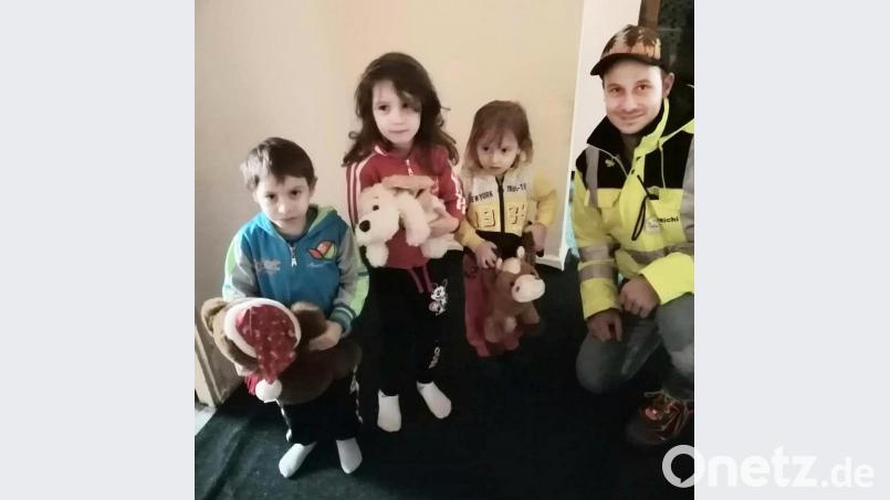 Michael Honig (rechts) überreicht gespendete Plüschtiere an die Kinder hilfsbedürftiger Familien. Bild: exb