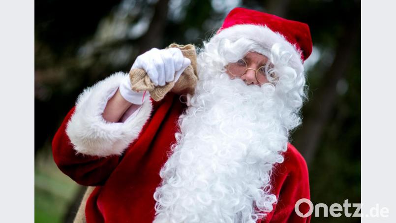 Ein Weihnachtsmann trägt einen Sack über der Schulter. Bild: Hauke-Christian Dittrich/dpa