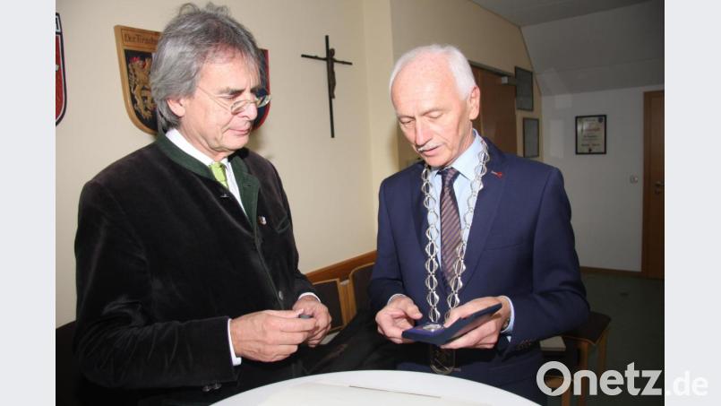 Bürgermeister Peter König hatte für Axel Bartelt (links) auch die Gemeinde Medaille, zudem das Buch „Schwarzenreuth – Geschichte und Geschichten“, das Hans Enders vor einigen Wochen auf den Markt brachte, als Willkommensgeschenke vorbereiten lassen. Bild: wro