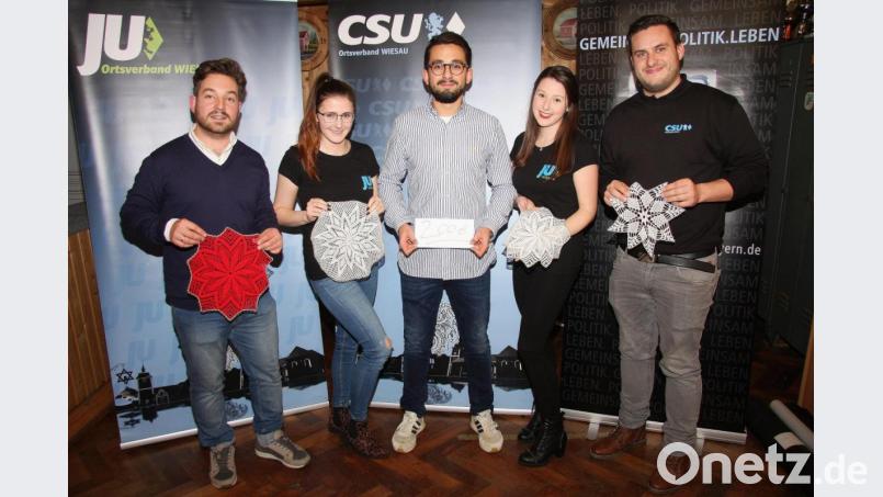 Gehäkelte Weihnachtssterne wurden am Wiesauer Weihnachtsmarkt angeboten. Der Erlös – 200 Euro - wird der Aktion „Sternstunden“ zur Verfügung gestellt. Im Bild (von links) Michael Dutz, Sophie Hecht, Florian Distner, Patricia Hecht und Alexander Hegen von der JU Wiesau. Bild: wro
