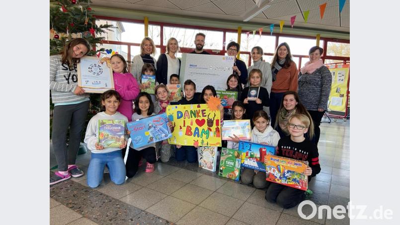 Einige der betreuten Kinder und das Team der Offenen Ganztagsschule an der Weidener Albert-Schweitzer-Schule sowie Rektorin Andrea Fröhler (hinten, Dritte von rechts) dankten BAM-Geschäftsführer Marco Bauer (hinten, Dritter von links) für die Spende. Vom Geld wurden Lernmaterialien für die Nachmittagsbetreuung angeschafft. Bild: exb/BAM GmbH