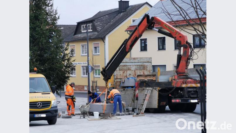 Die Mitarbeiter der Firma Seebauer platzierten am Tillyplatz drei große Granitblöcke. Im Vordergrund sind die Reifenspuren des Lastwagens noch erkennbar. Bild: gz
