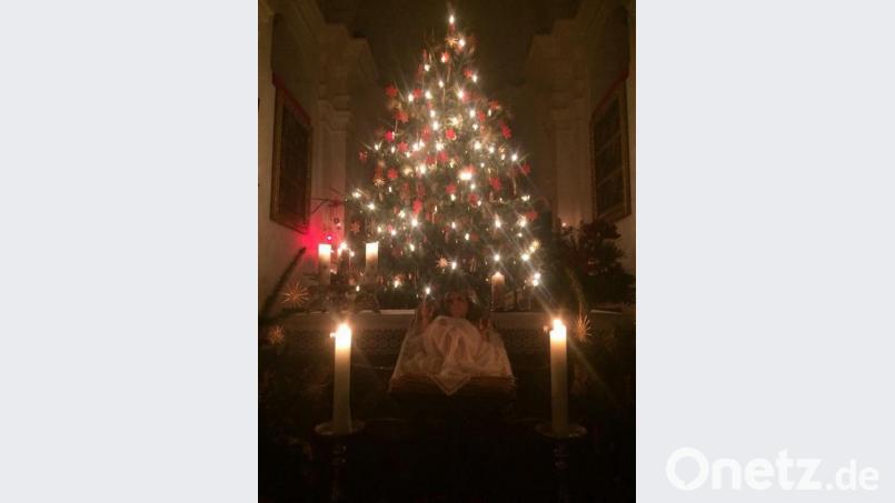 Der Christbaum in der Wallfahrtskirche St. Quirin ist geschmückt mit Strohsternen und roten Wachsanhängern. Davor steht die Krippe, die bei der Christnacht am Heiligen Abend um 24 Uhr im Mittelpunkt steht. Bild: trj