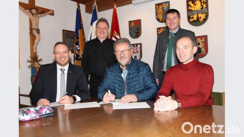 Bürgermeister Johann Maurer (sitzend, Mitte) unterzeichnet im Beisein von Geschäftsleiter Günter Gschwindler (sitzend, rechts) den Vertrag für das dritte Verfahren im Breitbandausbau. Darüber freuen sich auch Enrico Delfino (sitzend, links) und Josef Markl (hinten, rechts) von der Telekom sowie Diplom-Ingenieur Günther Pichlmaier. Bild: pi