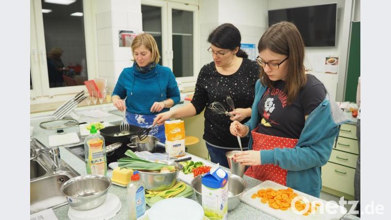 Mit Hilfe von Kursleiterin Christine Blab (Mitte) gelingt auch die Bechamelsoße. Bild: bl