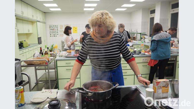 Kochkurs-Teilnehmerin Bernadette Rösch (im Vordergrund) passt auf, dass die Rouladen nicht anbrennen, während im Hintergrund hochkonzentriert an den Beilagen und Desserts gearbeitet wird. Bild: bl