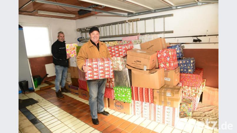 Bruno Friedl (rechts) hat in seiner Garage die insgesamt 165 Weihnachtspakete für die Johanniter-Weihnachtstrucker aufgetürmt. Beim Einladen hilft ihm Ludwig &quot;Lucky&quot; Wüst, der bereits elfmal mit dem LKW die Tour nach Rumänien gefahren ist. Bild: bey