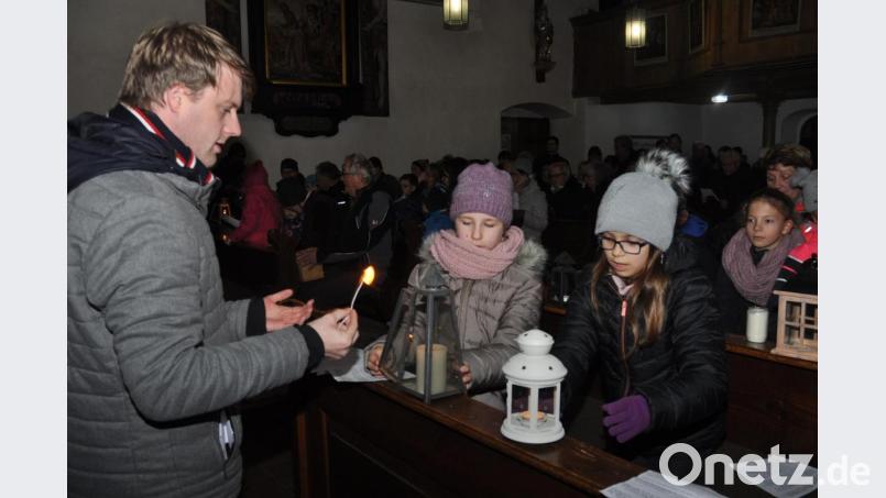 Pastoralreferent Maximilian Pravida verteilte das Friedenslicht an die Gläubigen, die mit ihren Laternen in die Simultankirche nach Altenstadt kamen. Bild: dob