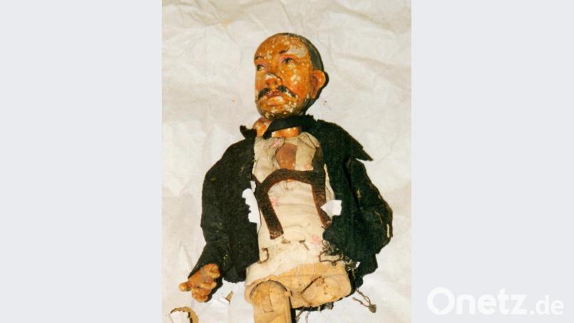 Dem Knecht fehlen das linke Bein und der linke Unterarm. Er trägt eine braune Wolljacke und Hosenträger aus braunem Leder sowie ein weißes Hemd mit Blumenmusterung. Bild: sef